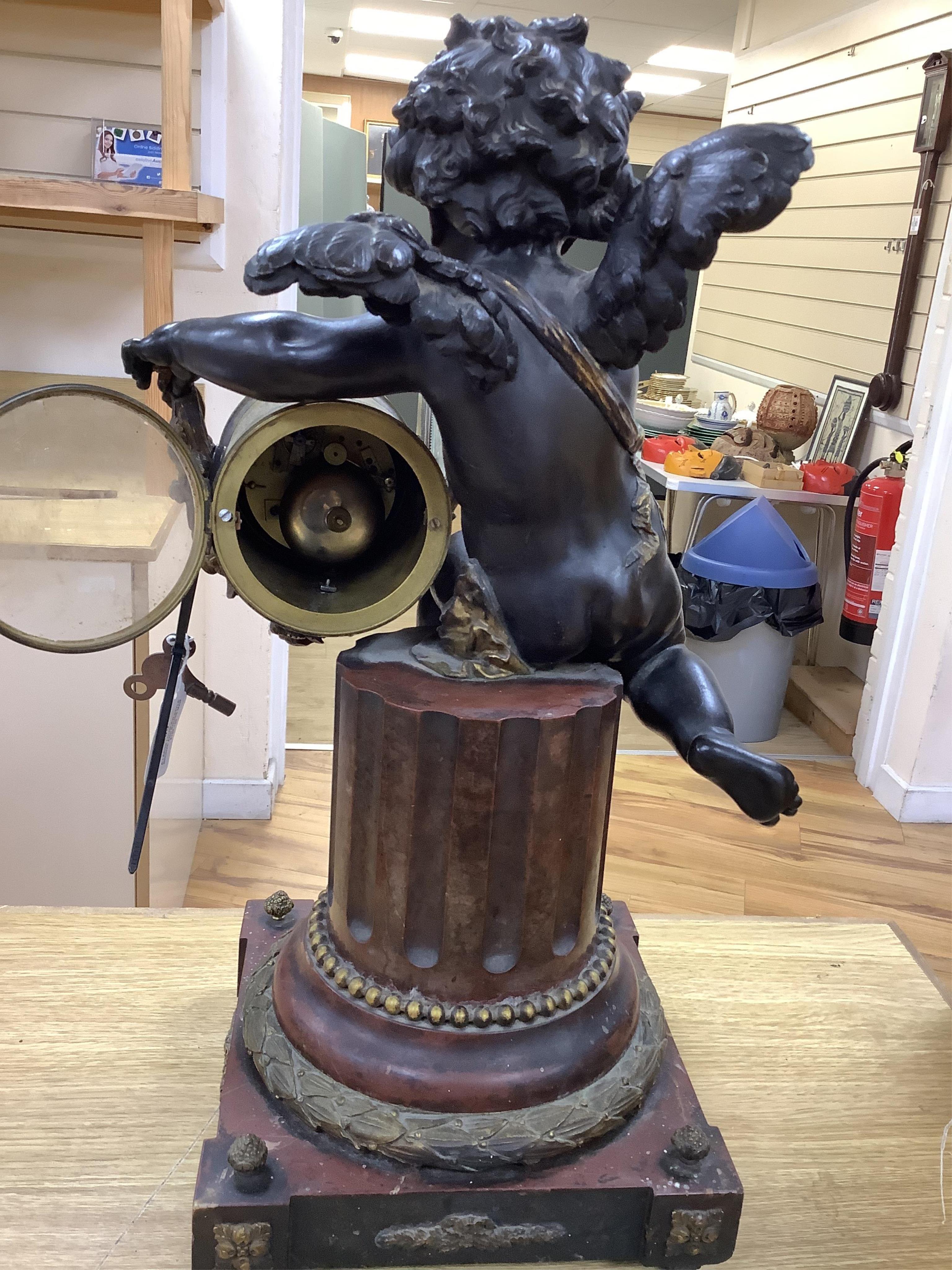 A large Louis XVI style bronze and rouge marble cherub clock, late 19th century, 56cm high